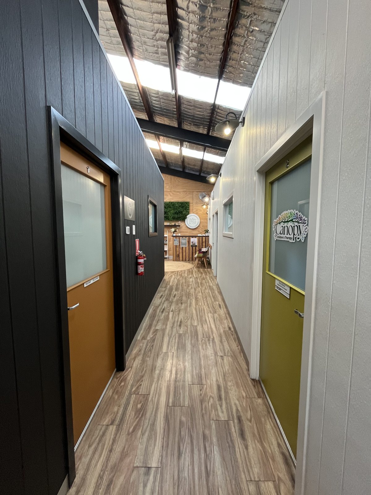 Hallway with orange and green practitioner room doors