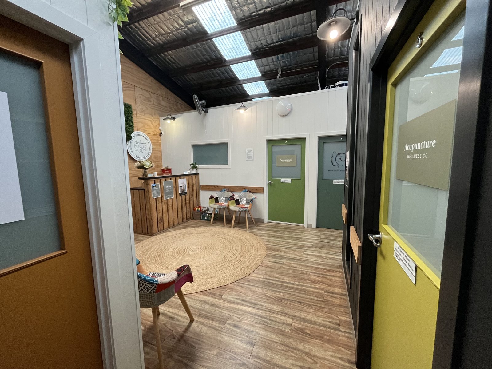 Wide view of the reception and hallway, with the Acupuncture Wellness Co. room visible