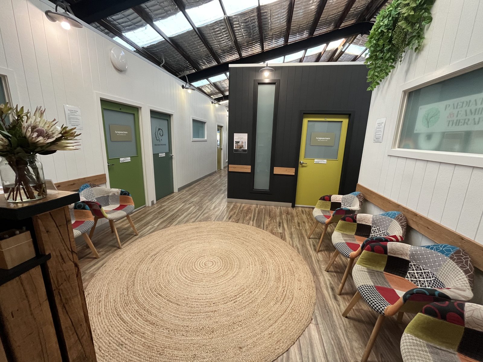 Waiting area with patchwork chairs and acupuncture and family therapy rooms